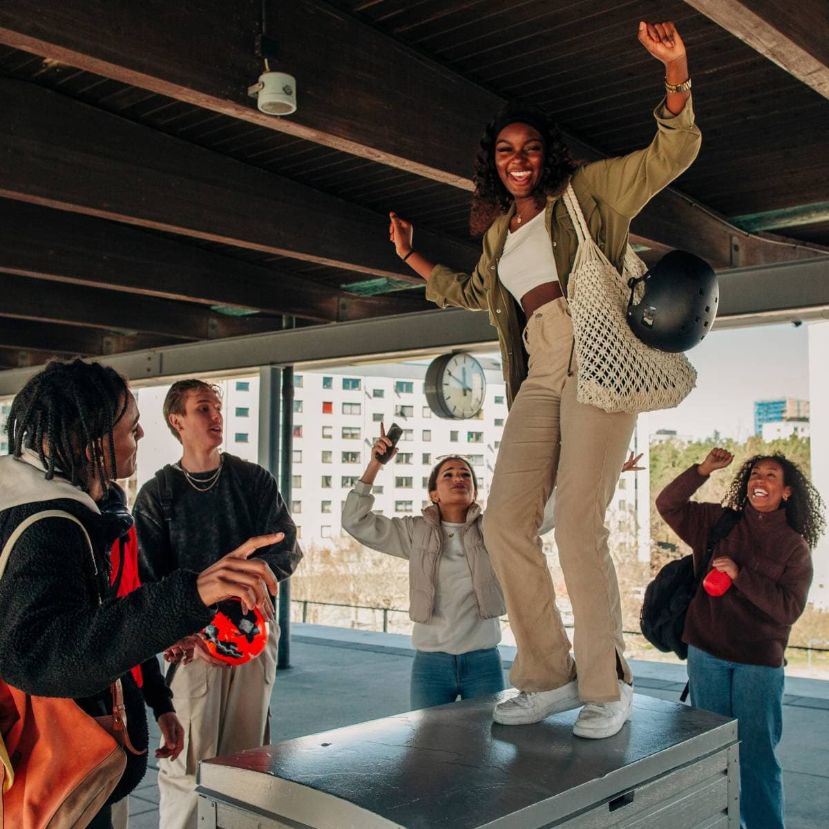 Ett gäng glada ungdomar har samlats på tågperrongen vid studentbostäderna.  
