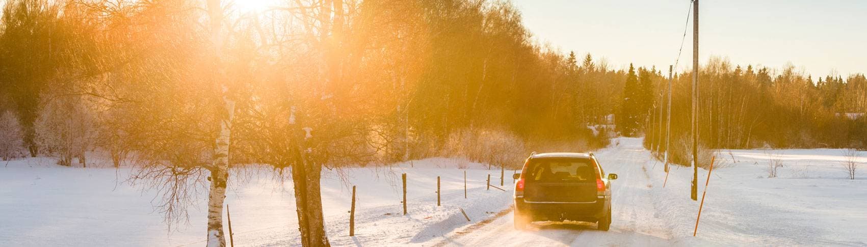 Bil åker på snötäckt väg