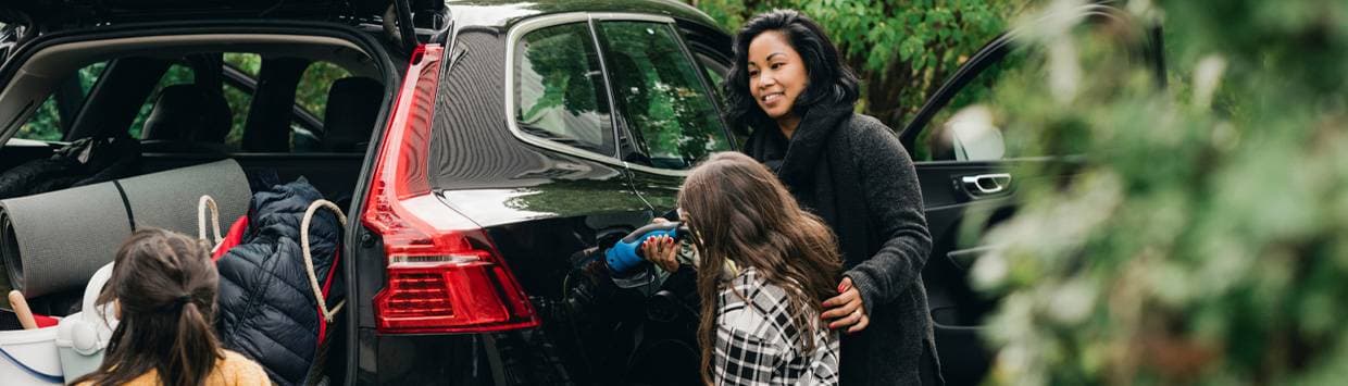 kvinna och barn som laddar elbil