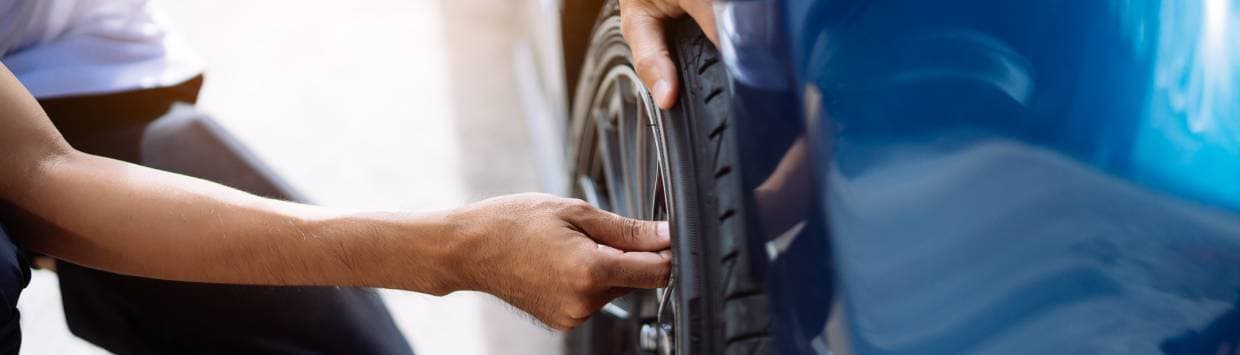 hand kontrollerar lufttryck i bildäck