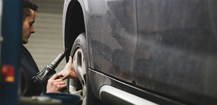 En man reparerar en bil