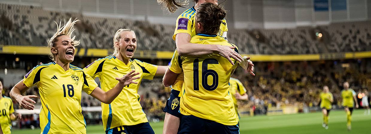 Flera fotbollsspelare springer mot varandra och kramar om varandra.