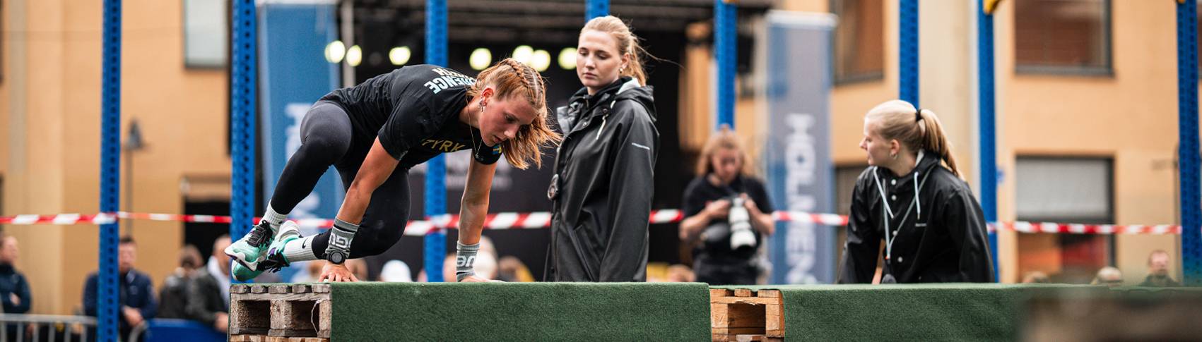 Fitnesstjej hoppar &ouml;ver ett hinder.