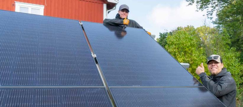 Markmonterade solceller och två installatörer